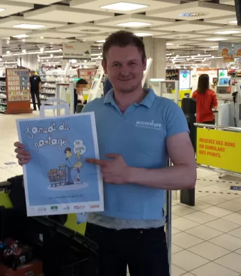 Corporate Social Responsibility Website Examples Where Anyone Can Participate : Corporate volunteer giving away shopping bags to gather donations for the needy in a supermarket during "Sharing Saturday" non-profit association in Geneva, Switzerland