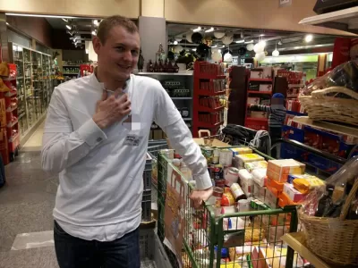 Corporate Social Responsibility Website Examples Where Anyone Can Participate : Corporate volunteer filling up a cart of donations for the needy during "Sharing Saturday" non-profit association in Geneva, Switzerland